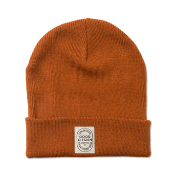 orange-red beanie with small white logo which says 